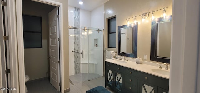 bathroom with double sink, tile floors, a shower with door, toilet, and oversized vanity