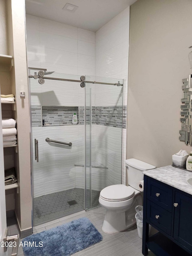 bathroom with an enclosed shower, toilet, vanity, and tile floors