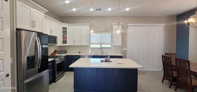 kitchen featuring white cabinets, a kitchen island, hanging light fixtures, and stainless steel appliances