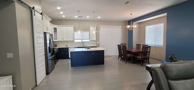 kitchen featuring pendant lighting, white cabinets, a chandelier, a barn door, and stainless steel refrigerator with ice dispenser