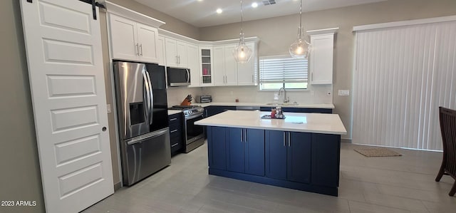 kitchen featuring white cabinetry, appliances with stainless steel finishes, a center island, tasteful backsplash, and pendant lighting