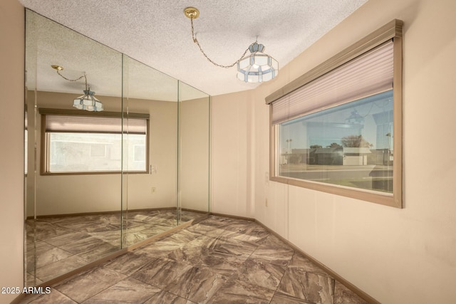 unfurnished room featuring a textured ceiling