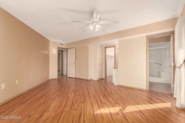 unfurnished room featuring a textured ceiling, ceiling fan, and light hardwood / wood-style flooring