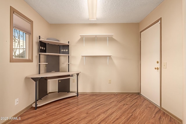 unfurnished office featuring a textured ceiling and light wood-type flooring