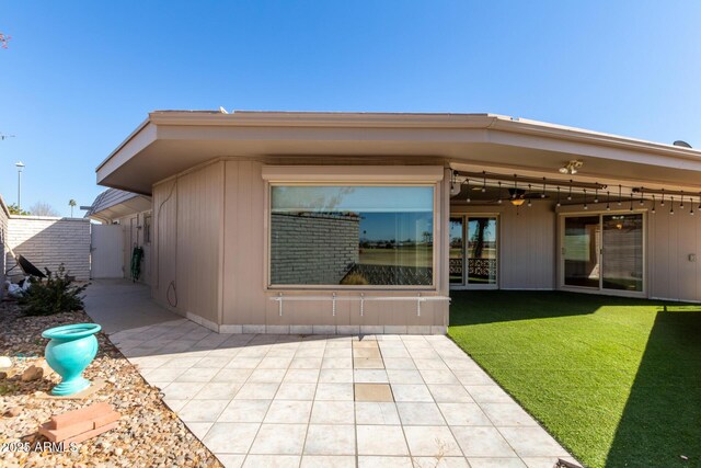 back of house featuring a patio area and a lawn