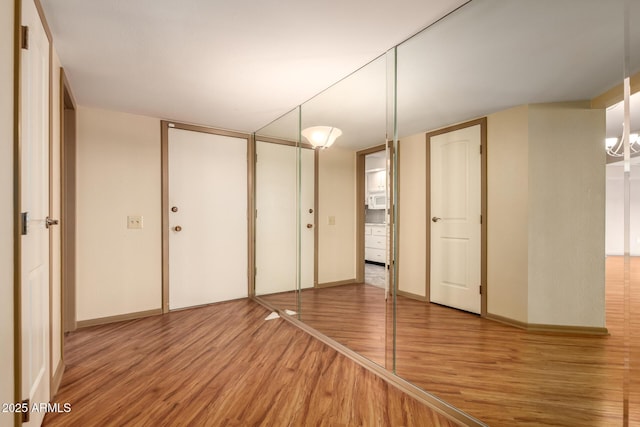 unfurnished bedroom with an inviting chandelier and hardwood / wood-style floors