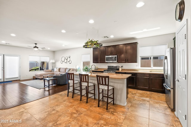 3022 E Santa Fe Ln, Gilbert, AZ 85297 - kitchen featuring stainless steel appliances, plenty of natural light, a breakfast bar, recessed lighting, and dark brown cabinets