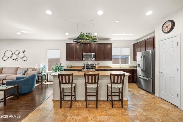 3022 E Santa Fe Ln, Gilbert, AZ 85297 - kitchen with appliances with stainless steel finishes, plenty of natural light, open floor plan, dark brown cabinets, and recessed lighting
