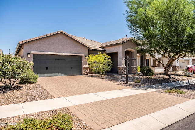 3022 E Santa Fe Ln, Gilbert, AZ 85297 - ranch-style house with stucco siding, an attached garage, decorative driveway, stone siding, and a tiled roof
