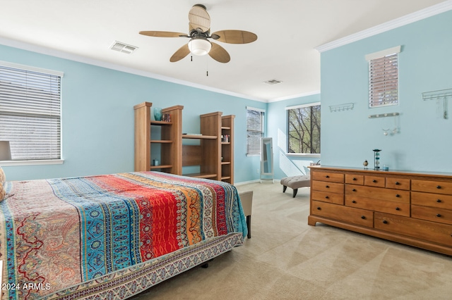 carpeted bedroom featuring crown molding and ceiling fan