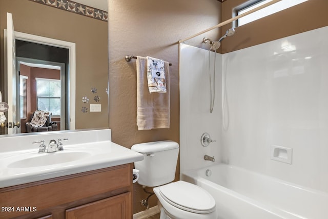 full bath with healthy amount of natural light, vanity, toilet, washtub / shower combination, and a textured wall