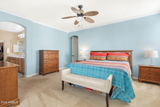 bedroom with ensuite bathroom, ornamental molding, light colored carpet, and ceiling fan