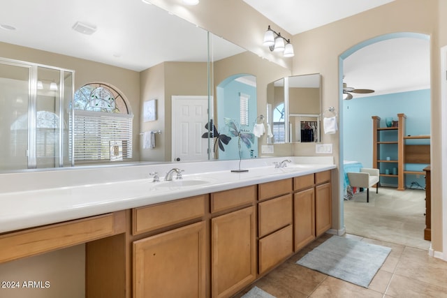 bathroom featuring a shower with door, vanity, tile patterned floors, and ceiling fan