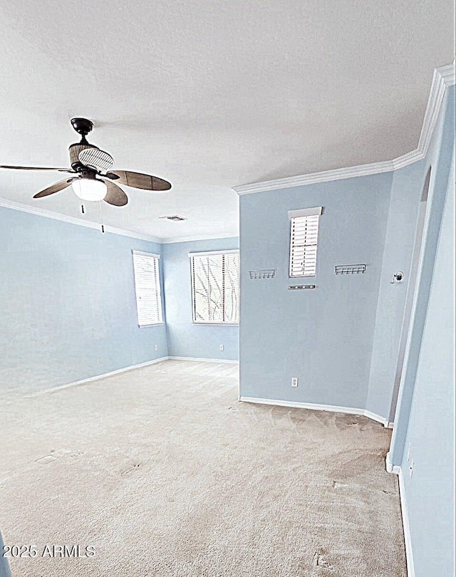 unfurnished room featuring crown molding, carpet floors, baseboards, ceiling fan, and a textured ceiling