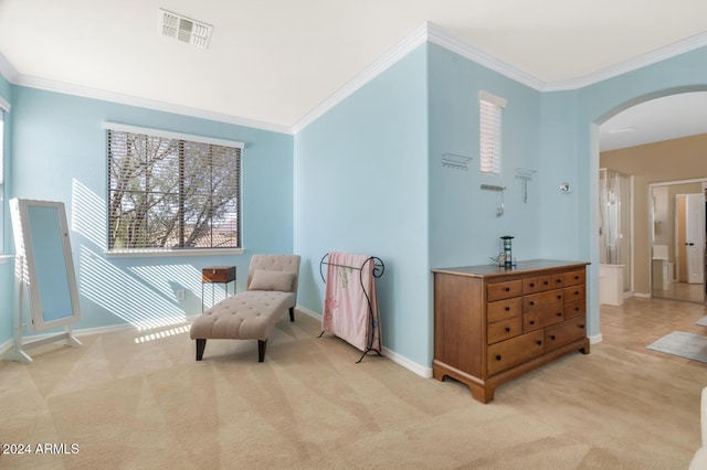 living area with arched walkways, ornamental molding, light carpet, and baseboards