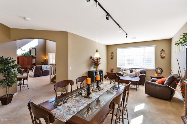 dining room with light carpet and track lighting