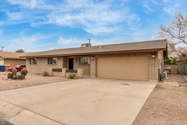 ranch-style home with a garage and central air condition unit