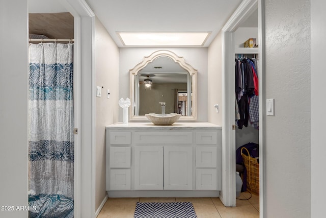 bathroom featuring tile patterned flooring, vanity, a skylight, and a shower with curtain