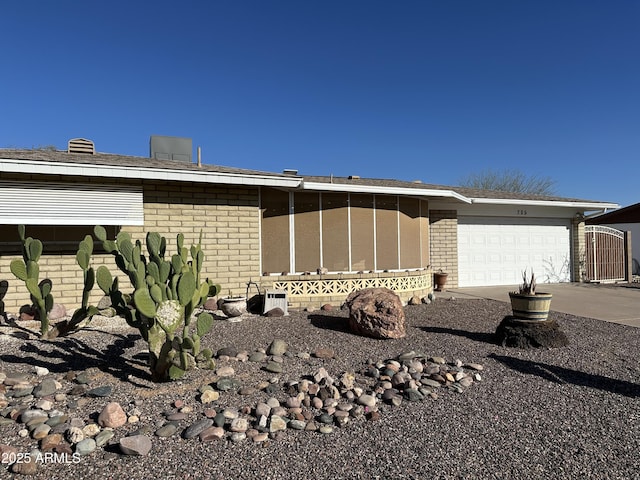 exterior space with a garage, driveway, and brick siding