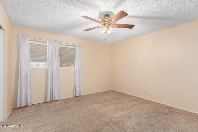 empty room featuring a textured ceiling, carpet flooring, and a ceiling fan