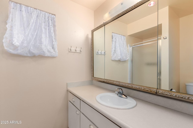 full bath featuring toilet, a shower stall, and vanity