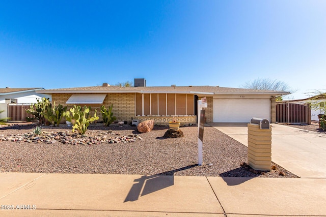 view of front of property with brick siding, concrete driveway, an attached garage, a gate, and fence