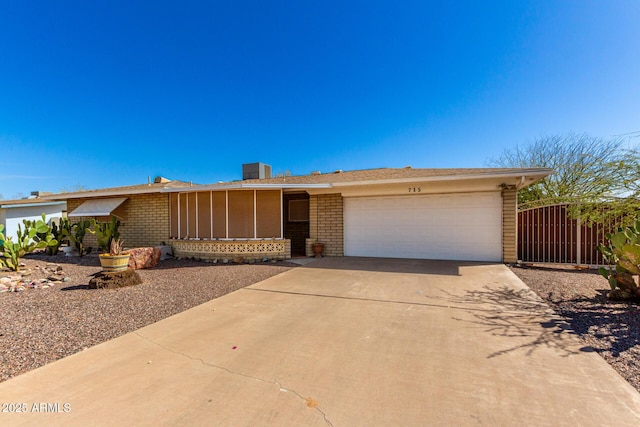 single story home with a garage, concrete driveway, and brick siding