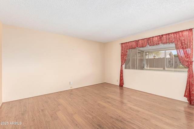 unfurnished room featuring a textured ceiling and wood finished floors