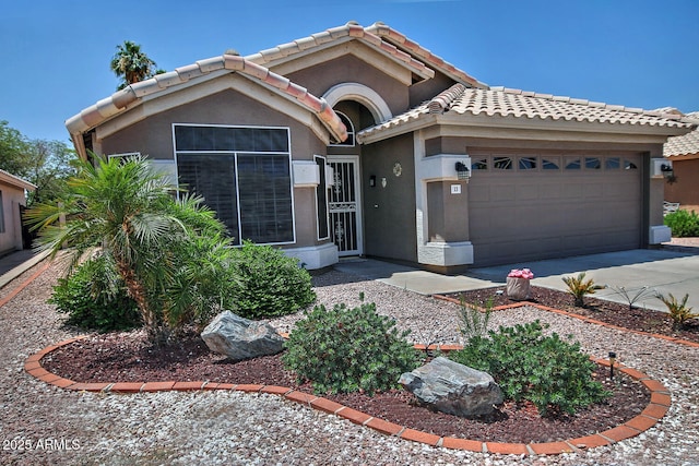1741 S Clearview Ave Unit 13, Mesa, AZ 85209 - view of front of house featuring an attached garage, a tile roof, stucco siding, and driveway