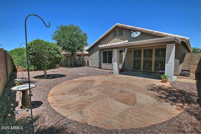 1741 S Clearview Ave Unit 13, Mesa, AZ 85209 - back of property with stucco siding, a fenced backyard, a tiled roof, and a patio area