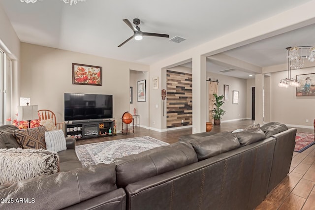 living room with ceiling fan with notable chandelier