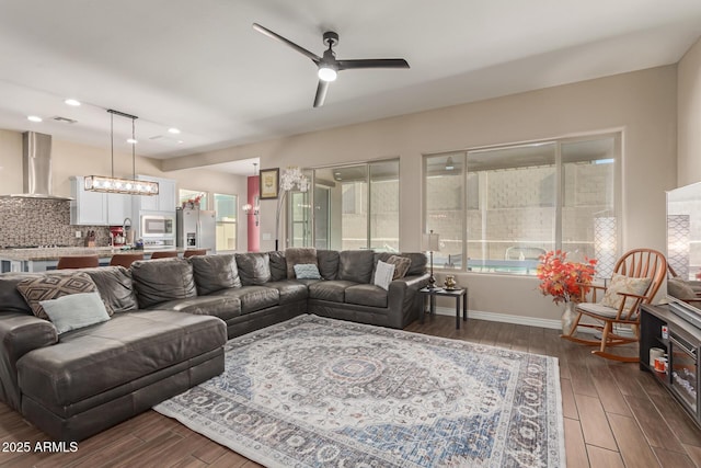 living room featuring ceiling fan with notable chandelier