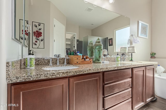 bathroom with hardwood / wood-style floors, a bathtub, and vanity