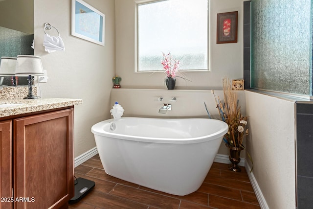 bathroom with a washtub and vanity