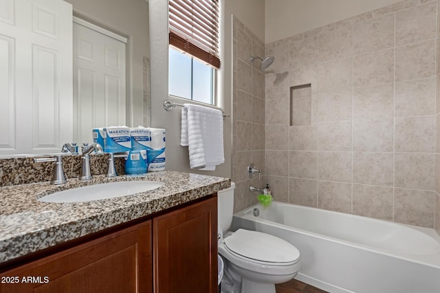 full bathroom featuring toilet, tiled shower / bath combo, and vanity