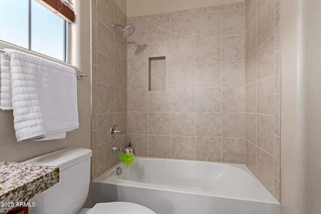 bathroom featuring toilet and tiled shower / bath combo