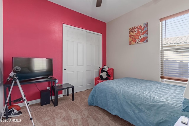 carpeted bedroom with ceiling fan and a closet