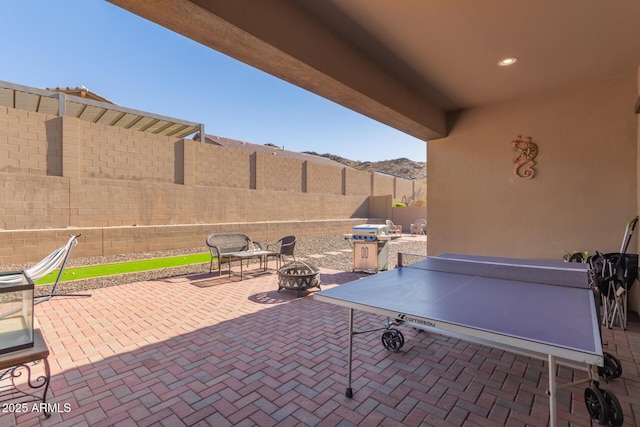 view of patio with a mountain view and a fire pit