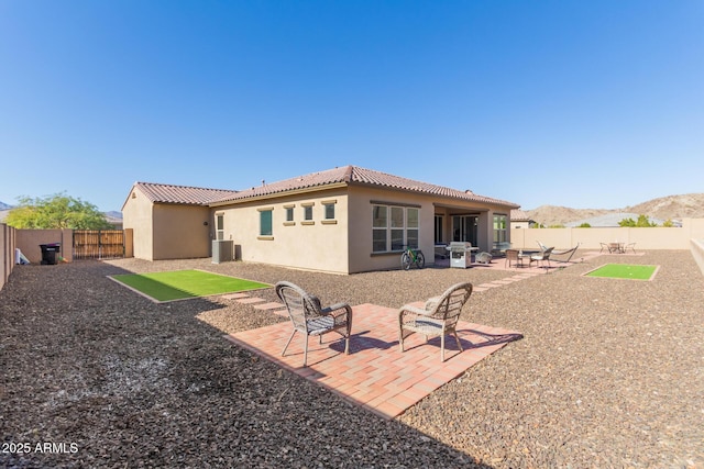 back of house with a mountain view, a patio area, and central AC