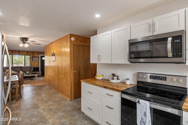 kitchen with wood counters, white cabinets, and stainless steel appliances