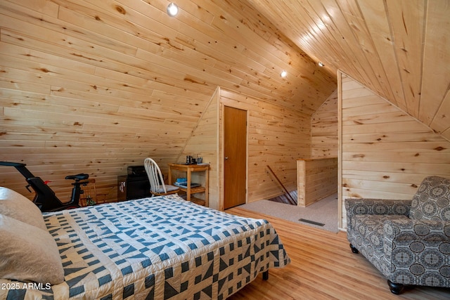 bedroom featuring lofted ceiling, wooden walls, wood finished floors, and wood ceiling