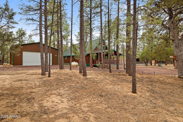 view of yard featuring a detached garage and an outdoor structure