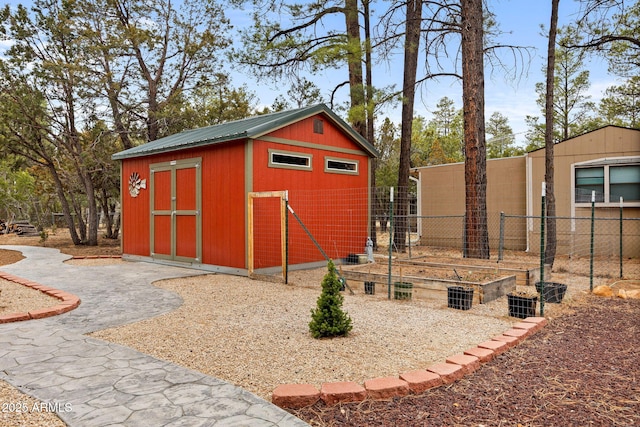 view of shed featuring fence and a vegetable garden