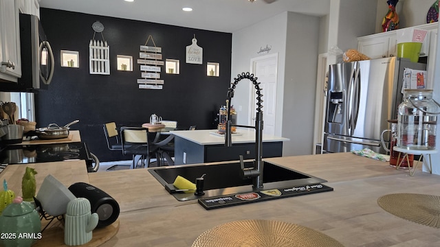 10036 W Chipman Rd, Tolleson, AZ 85353 - kitchen with stainless steel appliances, an accent wall, recessed lighting, white cabinetry, and a kitchen island