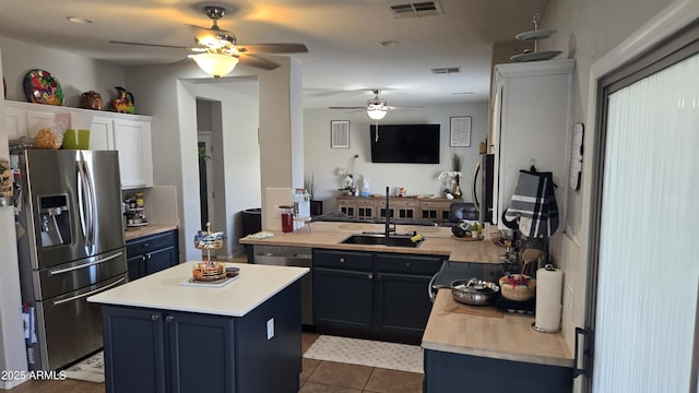 10036 W Chipman Rd, Tolleson, AZ 85353 - kitchen featuring appliances with stainless steel finishes, ceiling fan, light countertops, blue cabinetry, and dark tile patterned flooring