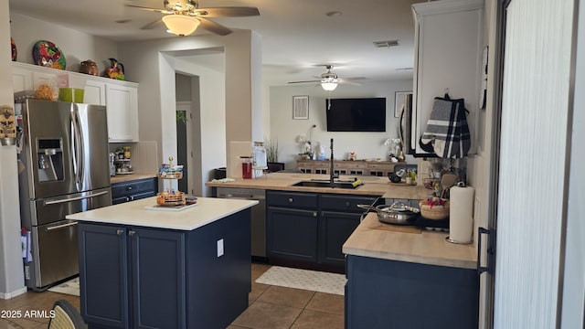 10036 W Chipman Rd, Tolleson, AZ 85353 - kitchen with stainless steel appliances, ceiling fan, dark tile patterned flooring, light countertops, and blue cabinetry