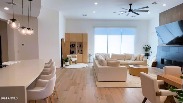 living room with ceiling fan and light hardwood / wood-style flooring