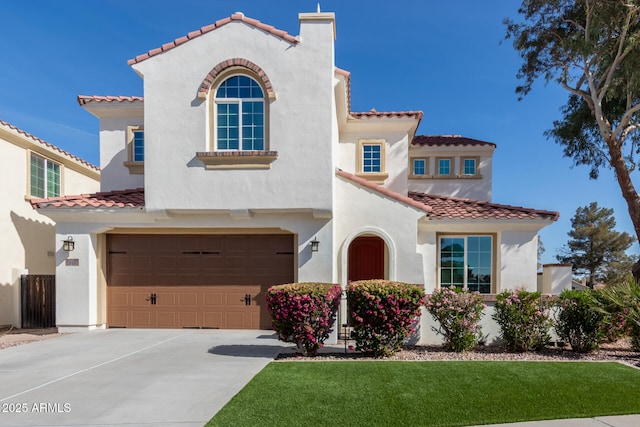 mediterranean / spanish home featuring a garage and a front yard