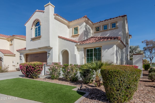 mediterranean / spanish-style house featuring a front lawn and a garage