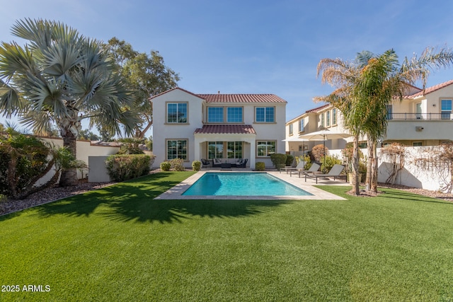 back of house with a patio area, a fenced in pool, and a lawn